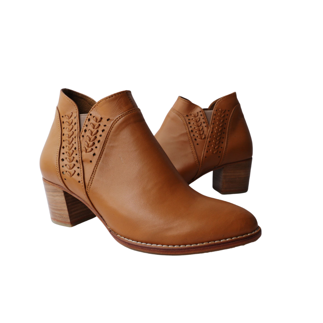 Ankle boots with elastic and zipper closure, featuring handwoven V-shaped detailing around the ankle. 5 cm block heels. Made from sheep leather, available in black and tan colors. A blend of style and comfort for a modern and versatile look.