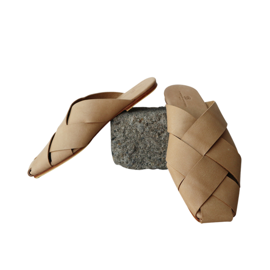 Beige leather mules with wide woven leather upper by Seminyak Leather Bali, providing a custom fit. Leather sole with nonslip rubber for confident steps. A blend of style and comfort for elevated fashion.