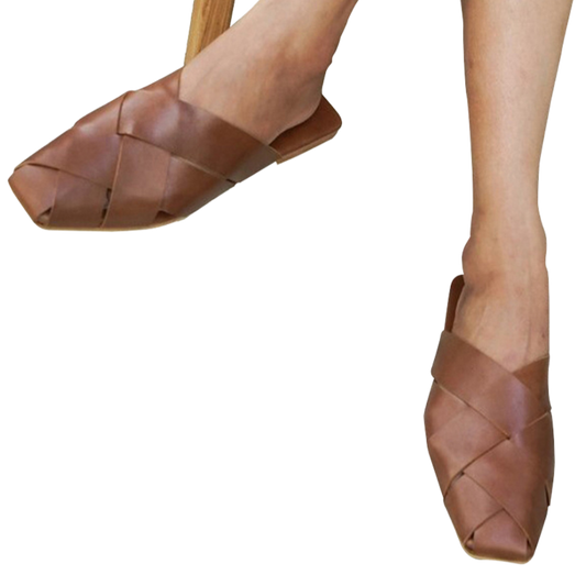 Tan leather mules with wide woven leather upper by Seminyak Leather Bali, providing a custom fit. Leather sole with nonslip rubber for confident steps. A blend of style and comfort for elevated fashion.