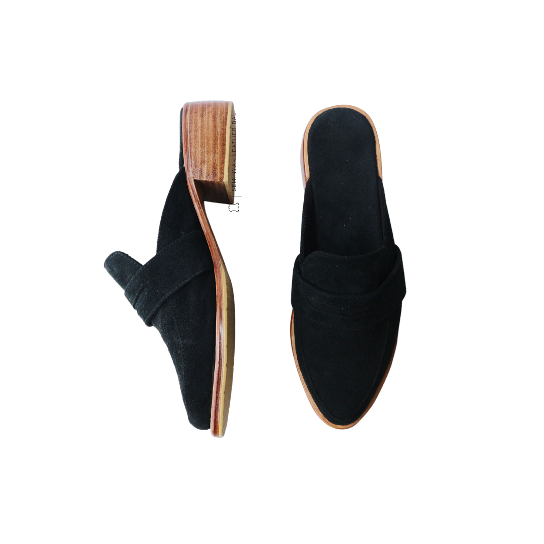 A pair of black suede loafer mules with wooden heels, displayed against a white background designs by Seminyak Leather Bali