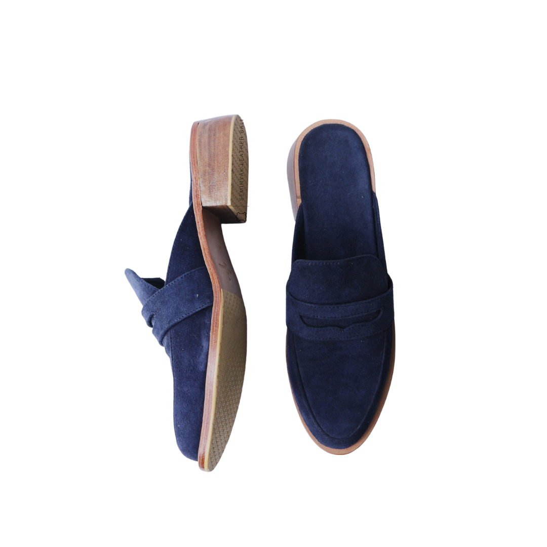 A pair of navy suede loafer mules with wooden heels, displayed against a white background designs by Seminyak Leather Bali