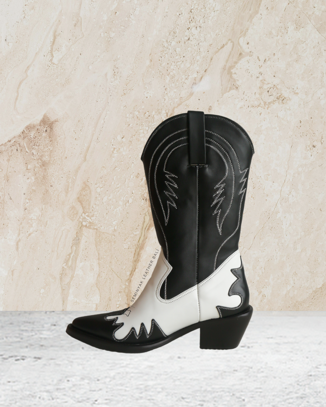 Black and white cowboy boot designs by Seminyak Leather Bali on a light marble background