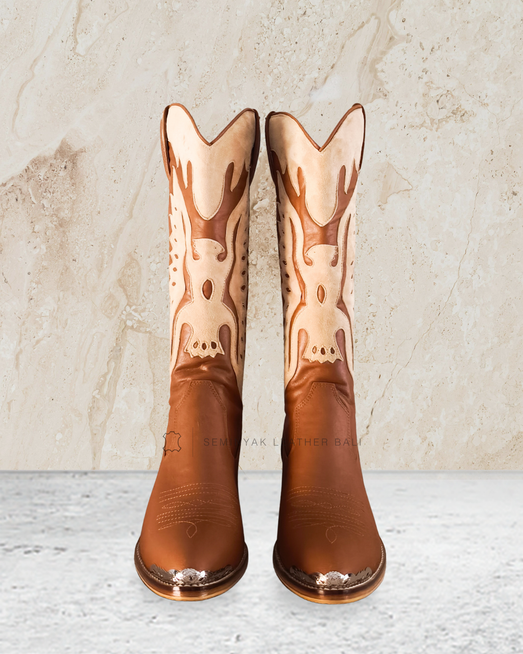 knee high cowboy boot with decorative patterns designs by Seminyak Leather Bali on a textured beige background