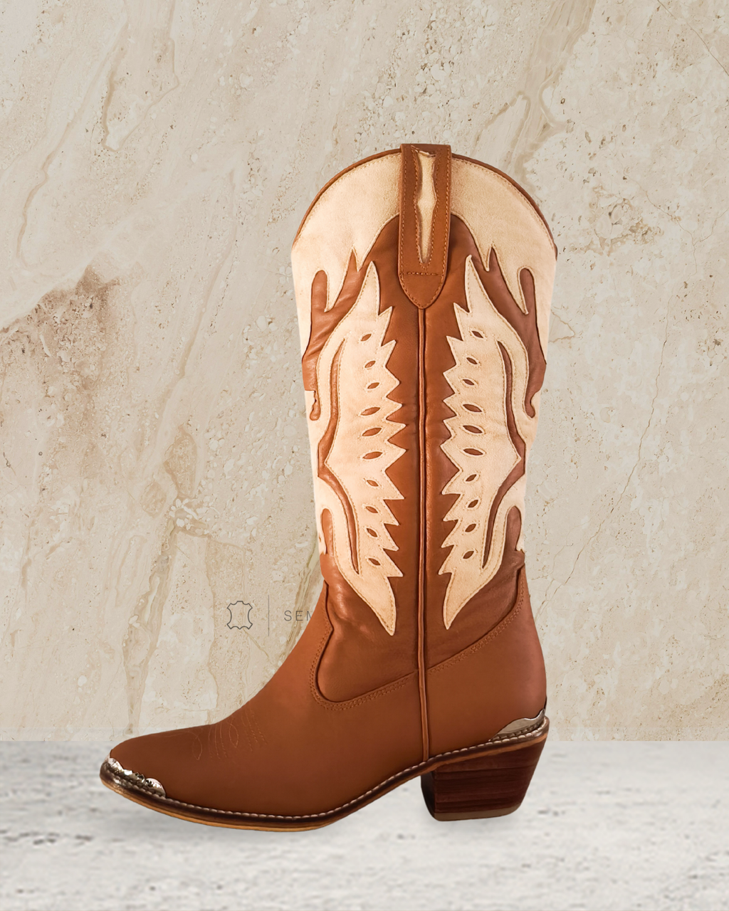 knee high cowboy boot with decorative patterns designs by Seminyak Leather Bali on a textured beige background