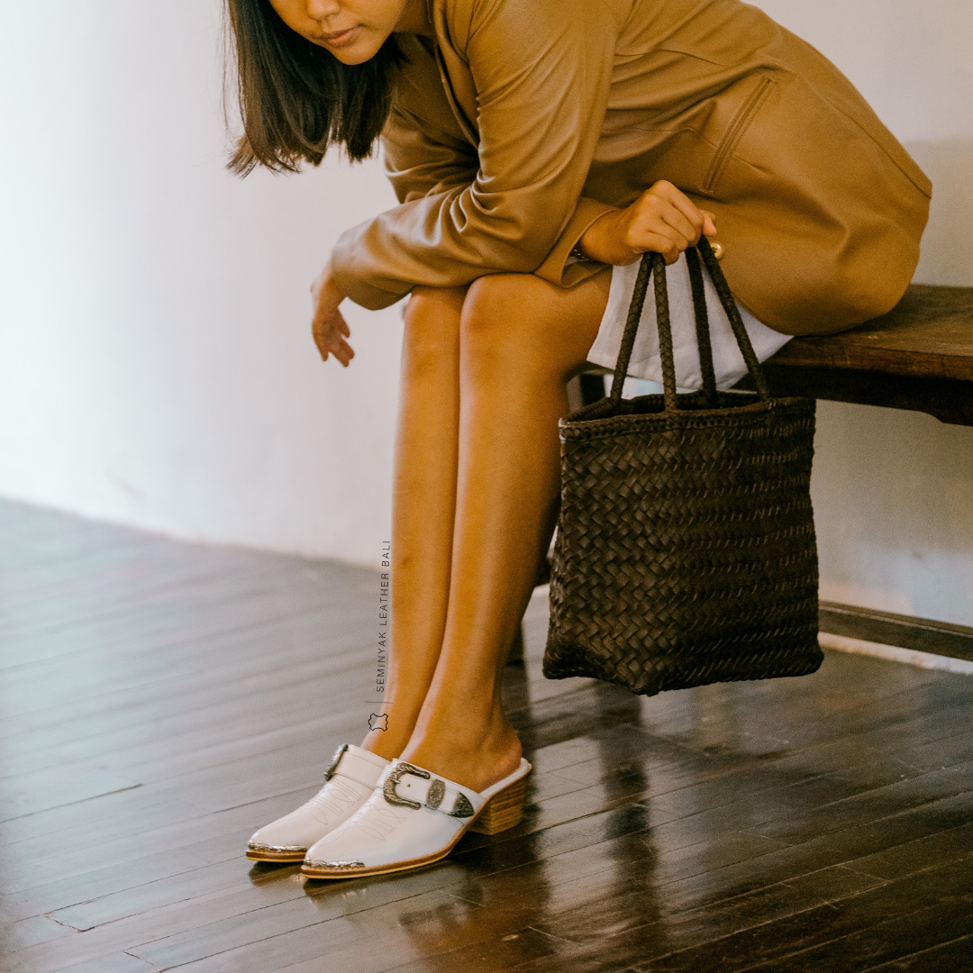 White pointy toe mules by Seminyak Leather Bali with western-style stitching on vamp and carved metal toe cap. 5 cm wooden Cuban heel in a natural finish. A blend of Western charm and contemporary elegance, all made of leather.