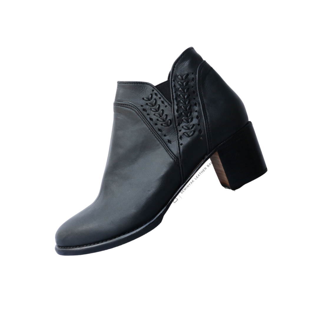A pair of black ankle boots with handwoven detailing around the ankle and a block heel designs by Seminyak Leather Bali.