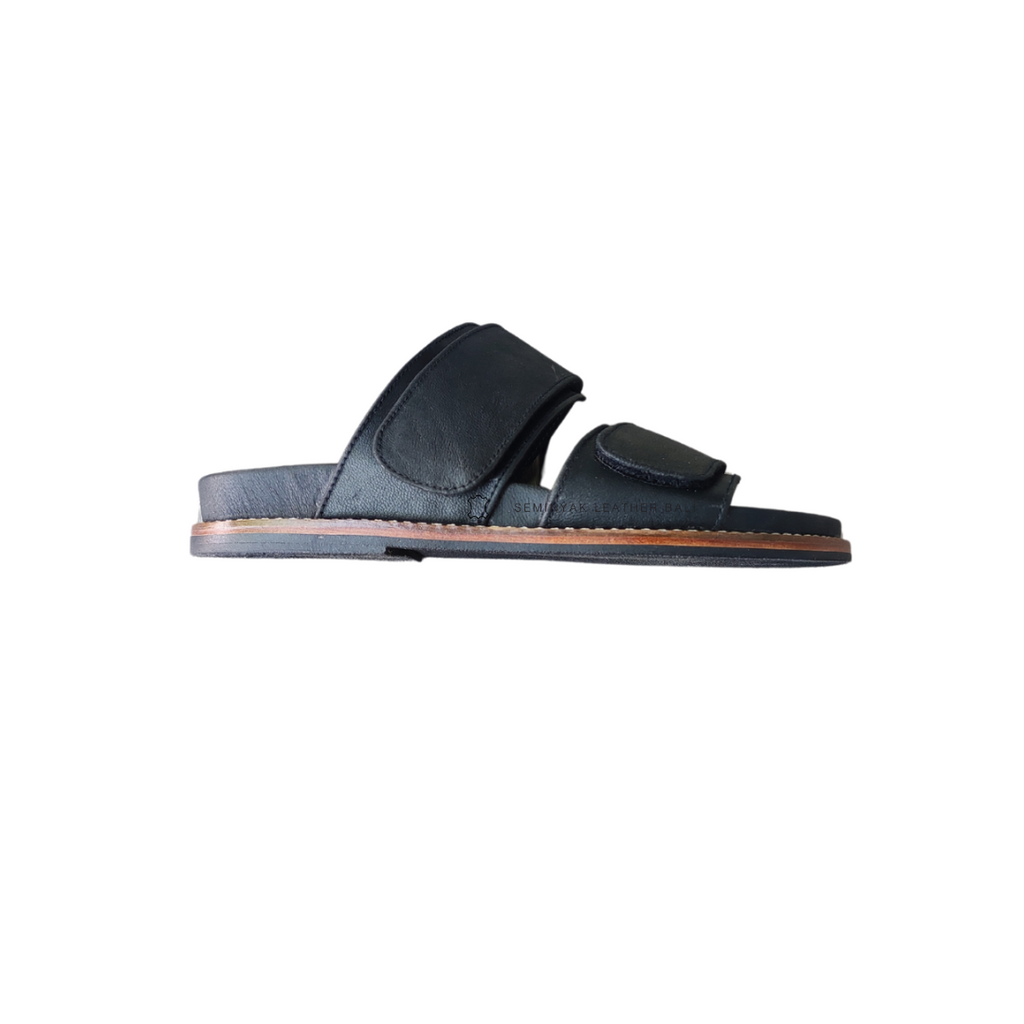 A pair of black sandal with double strap velcrow, displayed against a white background designs by Seminyak Leather Bali