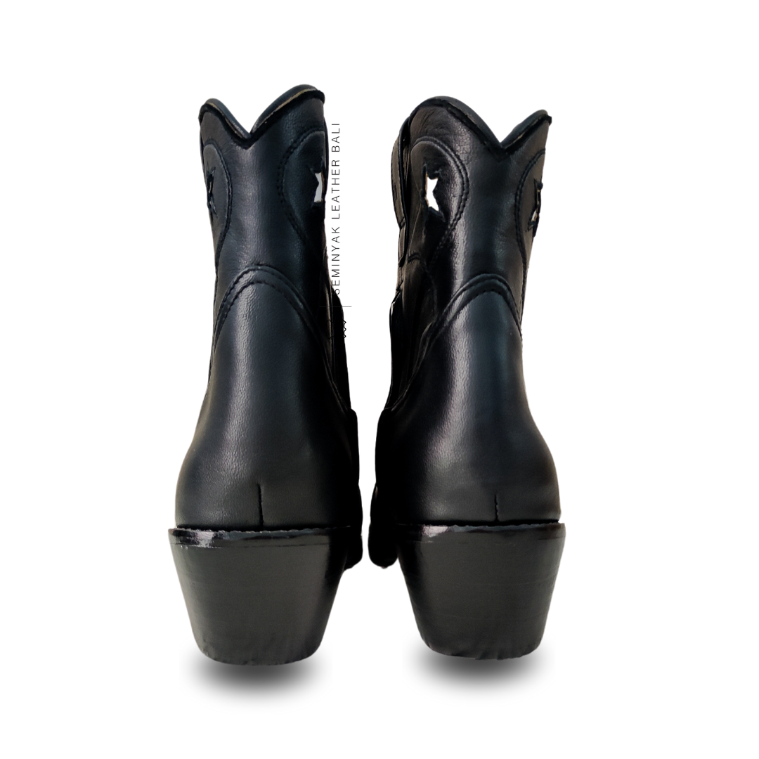 A pair of black and white cowboy boots with a pointy toe and cuban style heels designs by Seminyak Leather Bali.