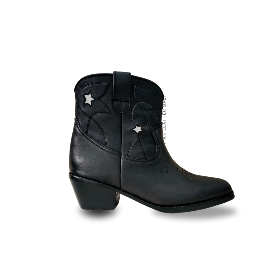 A pair of black and white cowboy boots with a pointy toe and cuban style heels designs by Seminyak Leather Bali.