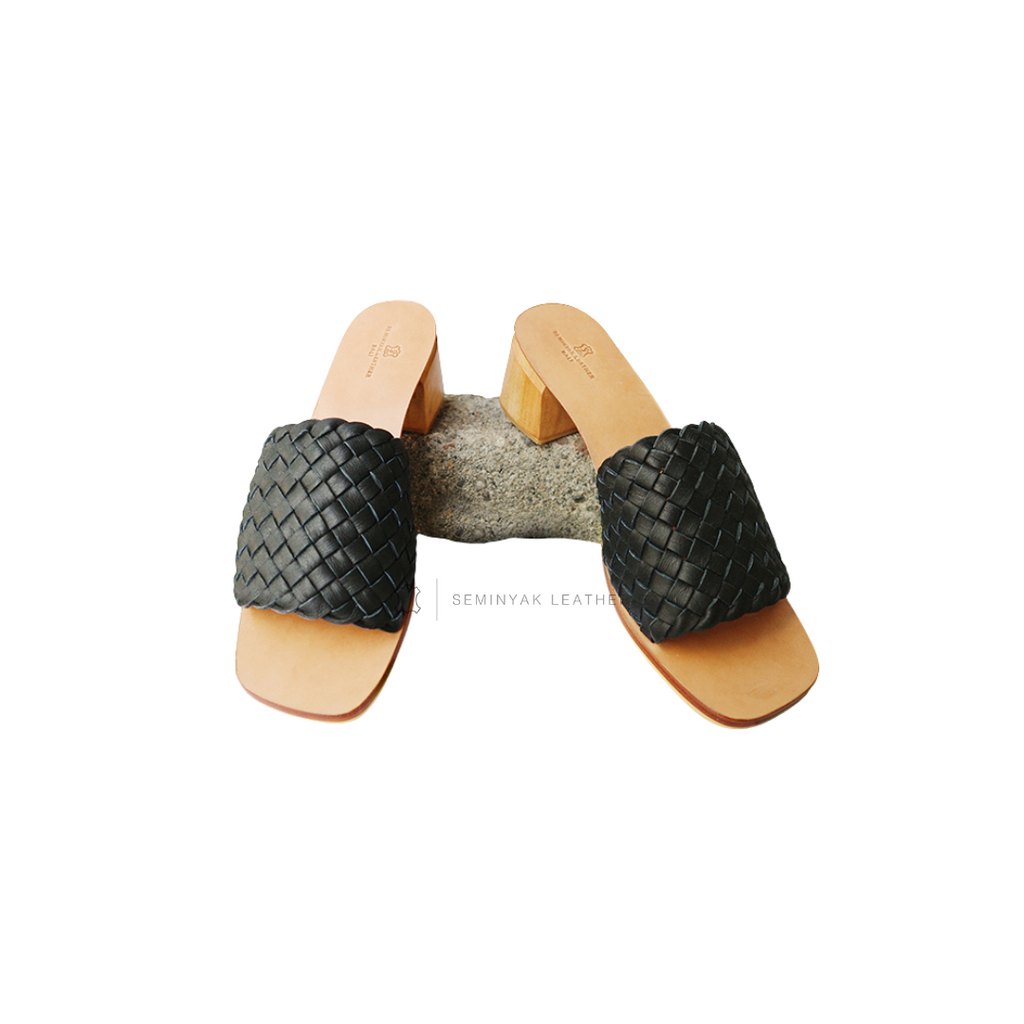 A pair of black woven heels with wooden block heels designs by Seminyak Leather Bali.
