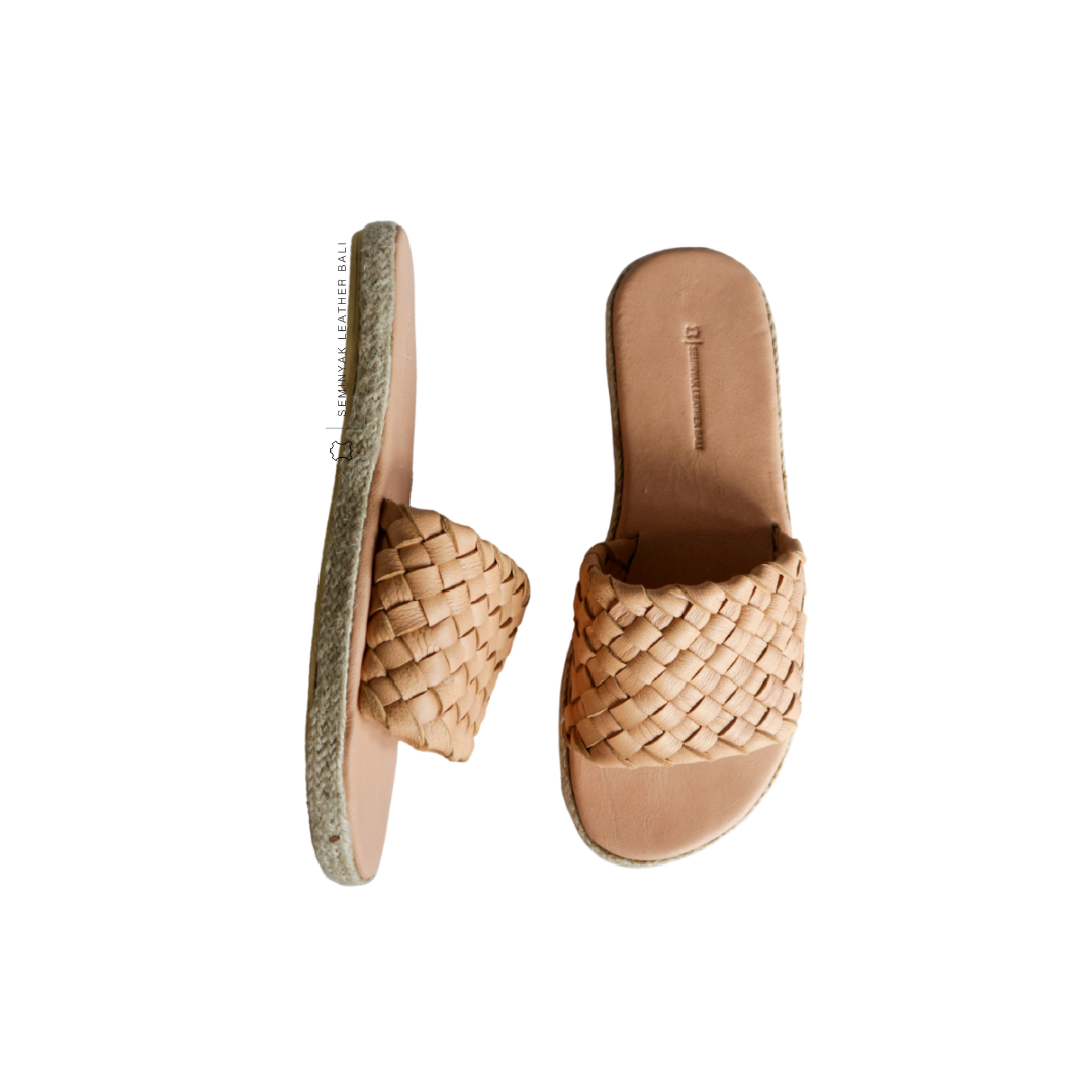 A pair of blush wide woven strap sandals with a cushioned sole displayed against a white background designs by Seminyak Leather Bali