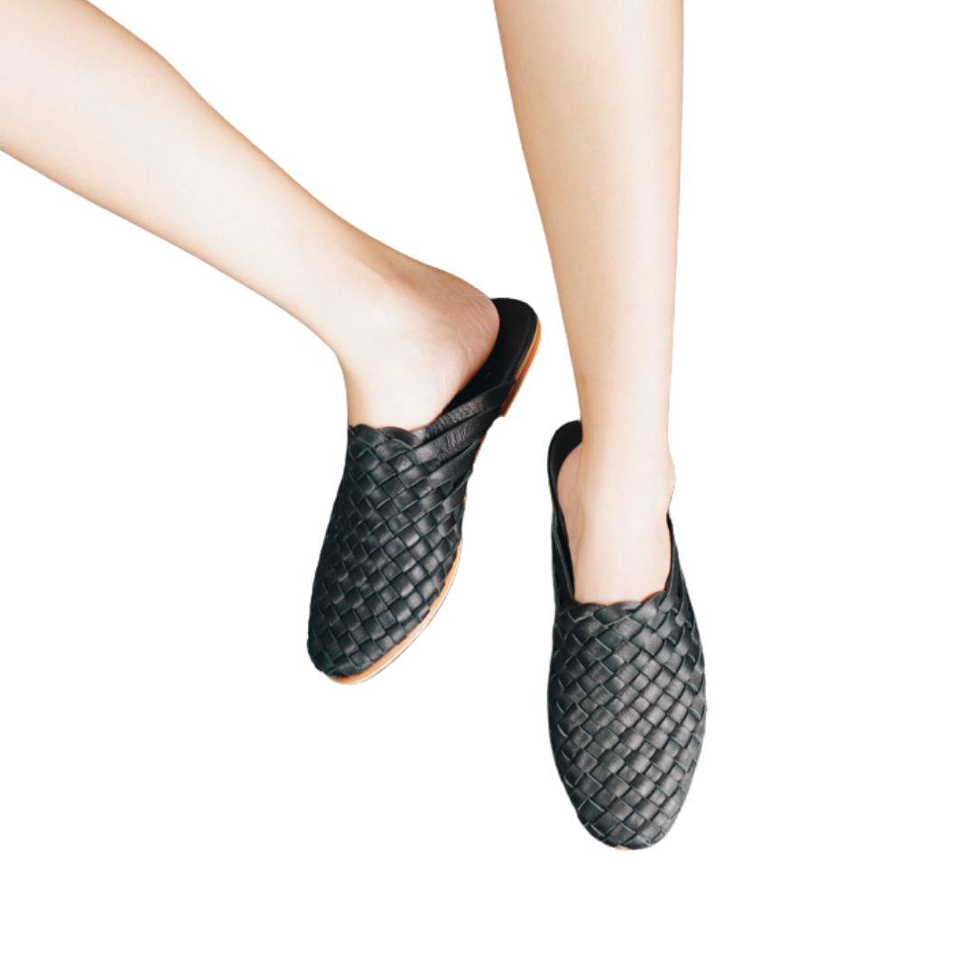 A pair of black woven mules  displayed against a white background designs by Seminyak Leather Bali