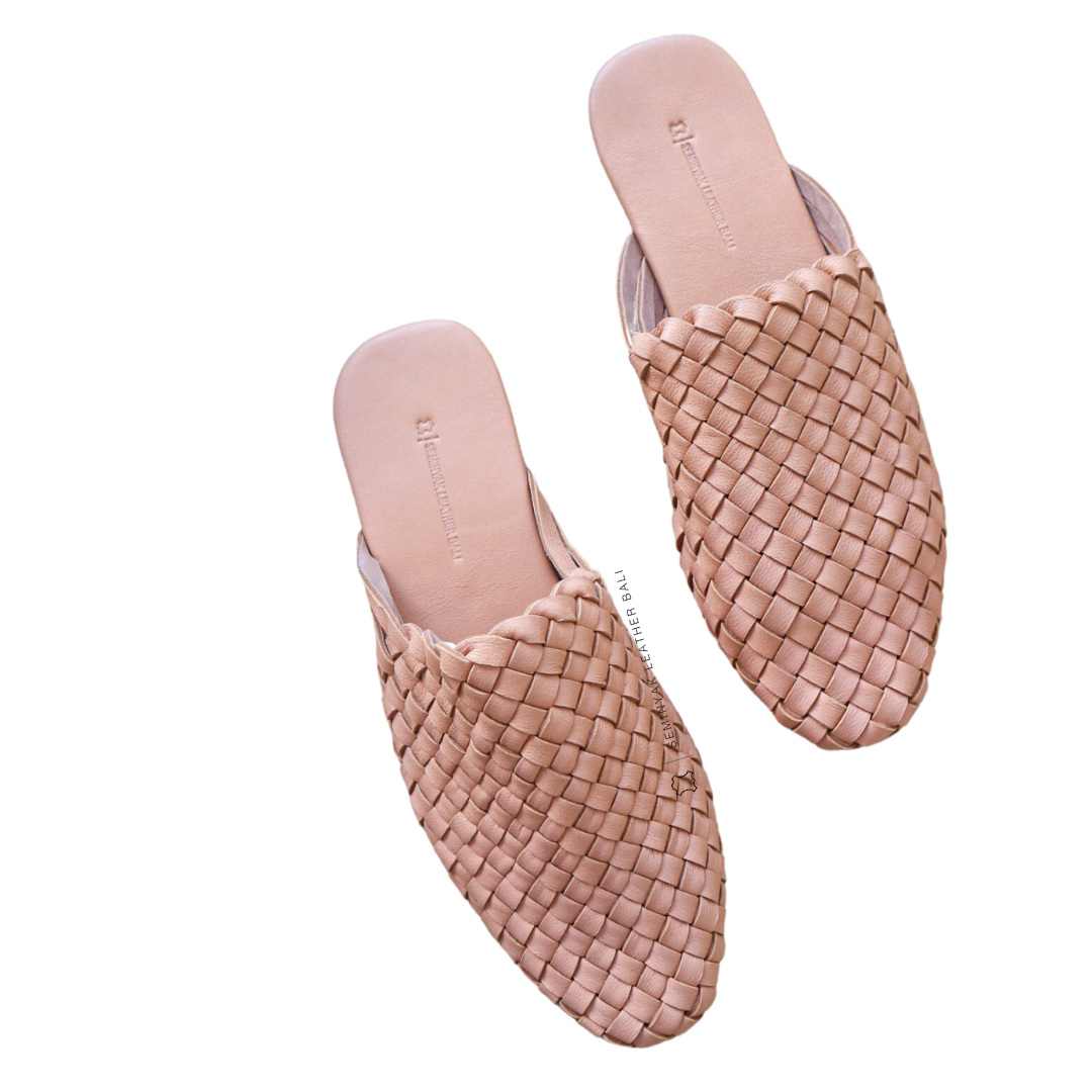 A pair of blush woven mules  displayed against a white background designs by Seminyak Leather Bali