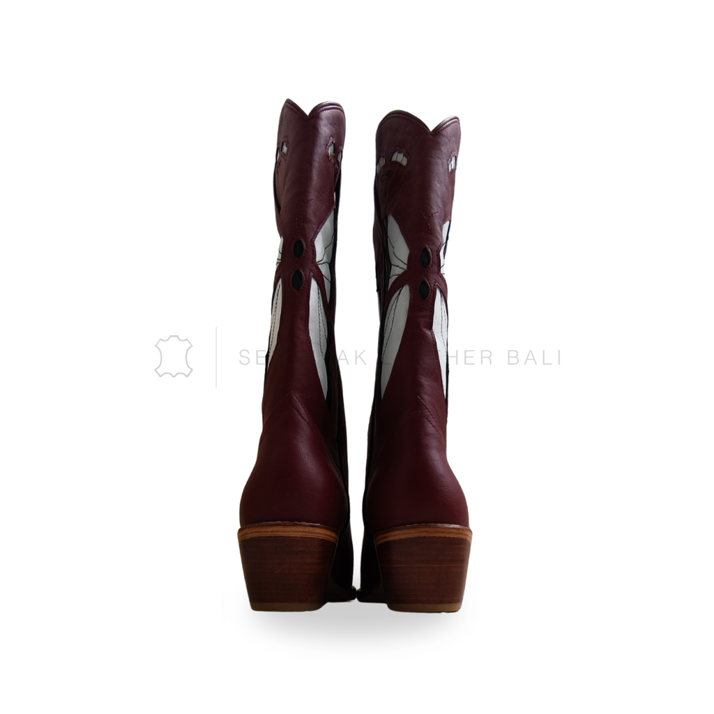 Pair of maroon knee-high boots with decorative patterns on a white background