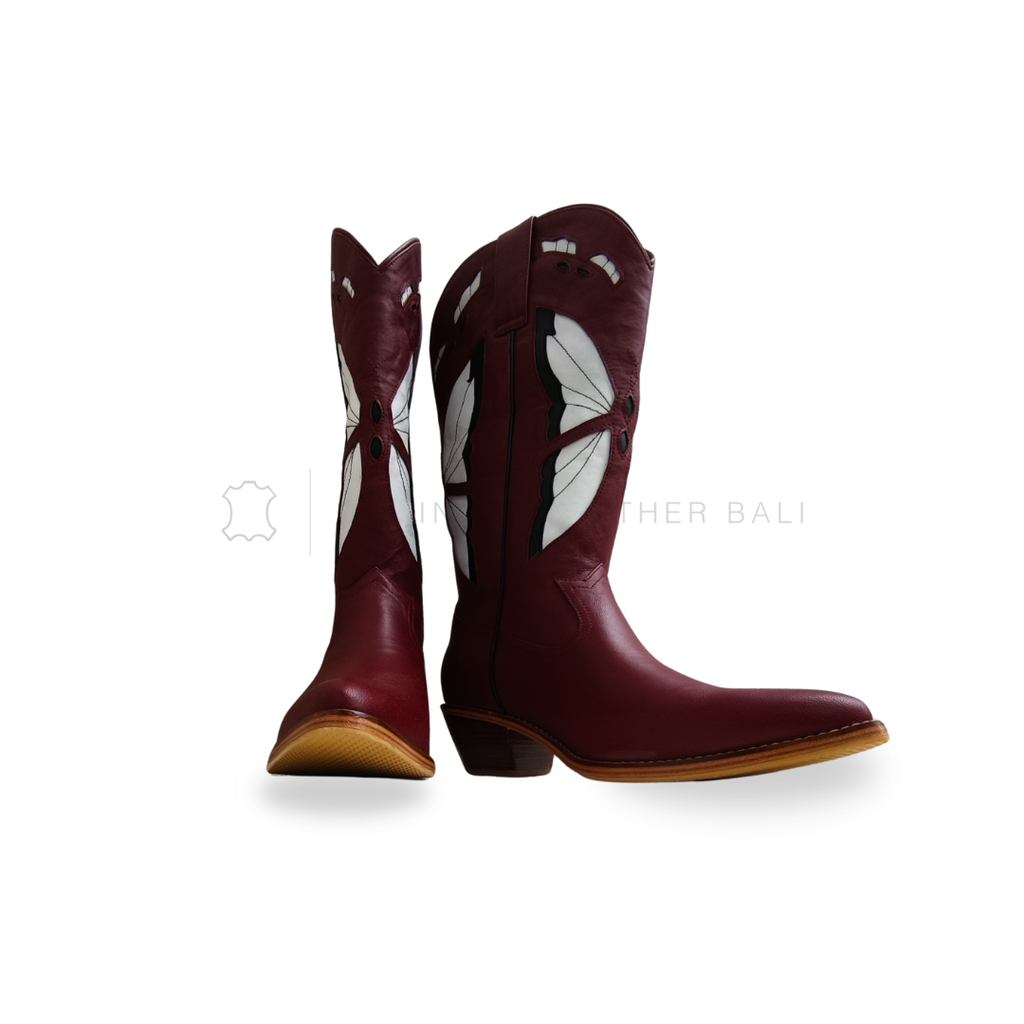 Pair of maroon boots with butterfly designs on a white background