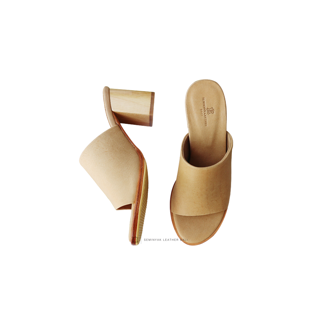 A pair of beige mule heels with wooden leather heels and wide straps designs by Seminyak Leather Bali
