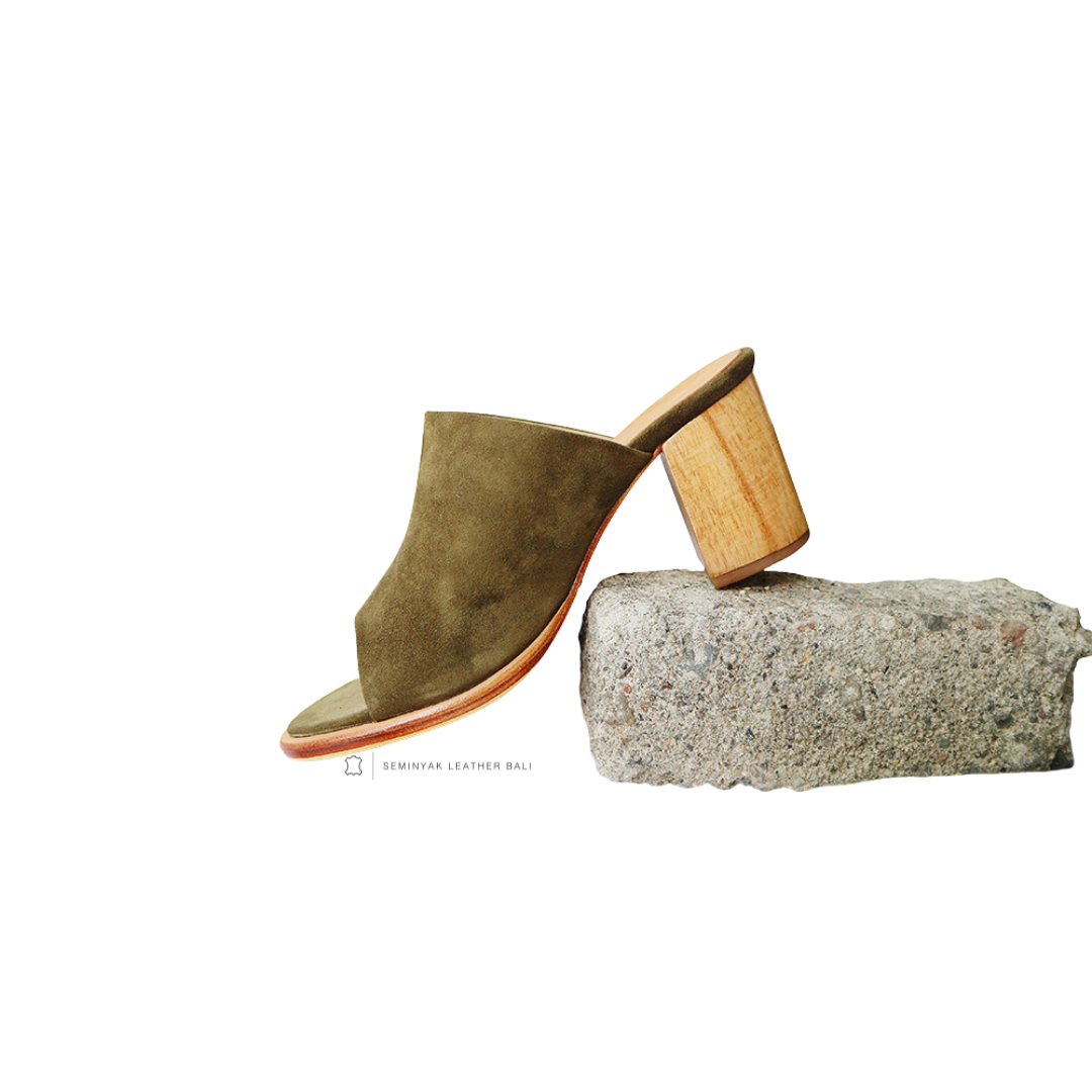 A pair of olive suede mule heels with wooden leather heels and wide straps designs by Seminyak Leather Bali
