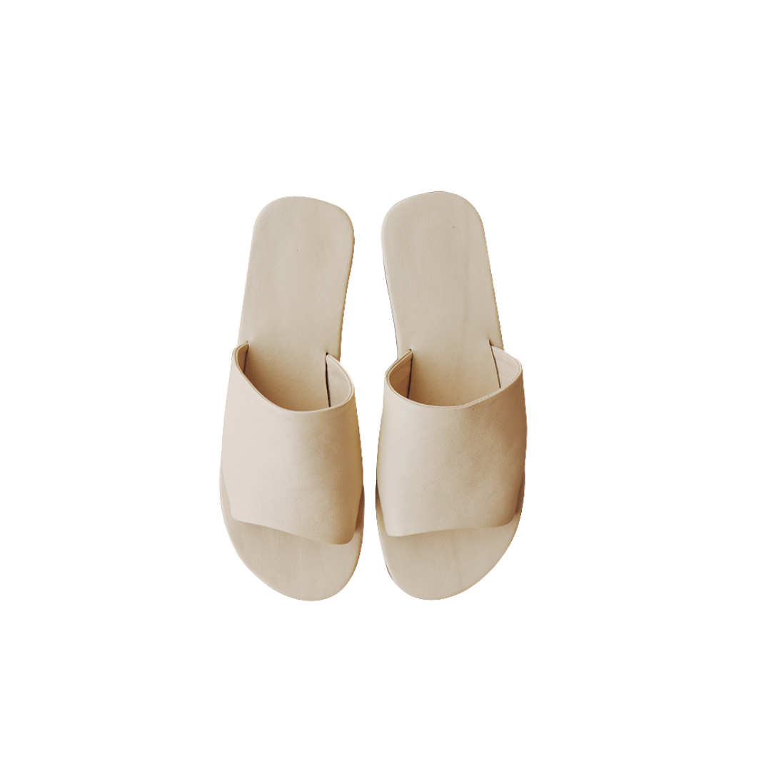 A pair of beige genuine goat leather slides with a wide strap designs by Seminyak Leather Bali