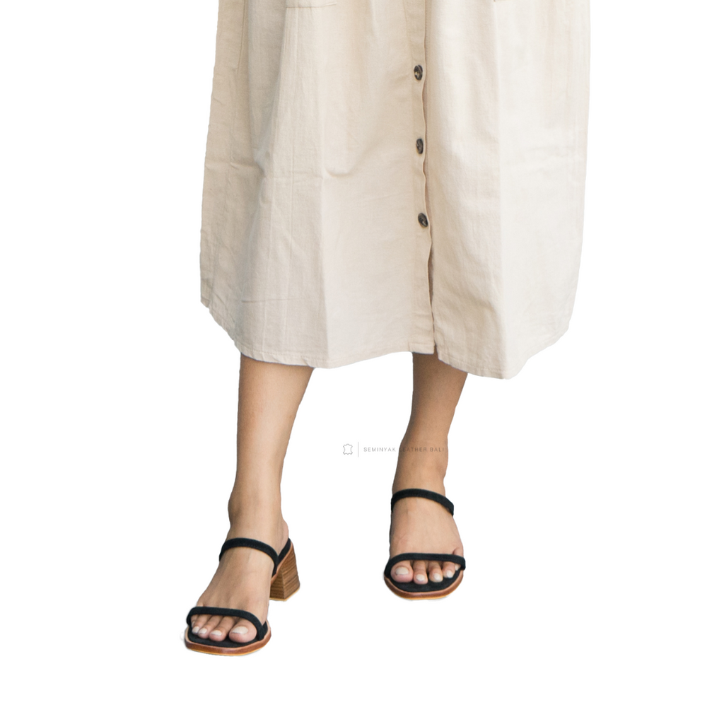 Person wearing a beige button-up dress with sandals on a white background designs by Seminyak Leather Bali