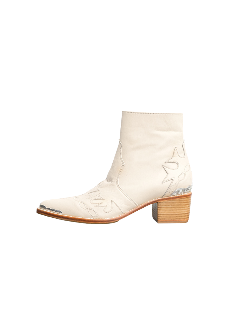 Cream-colored boots, with carved details on the front and back plus metal carving accessories, plus 5 cm high heels that look very elegant and charming. These boots are Canggu Boots, originating from Seminyak Leather Bali.