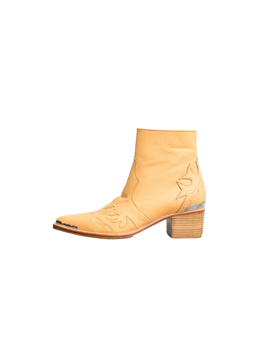 A picture of a Tan Boot, the boots are made of tan sheepskin with threaded carvings and additional metal carvings on the front and back as well as a ziper for ease of use and 5 cm high heels. These boots are Canggu Boots Carving from Seminyak Leather Bali
