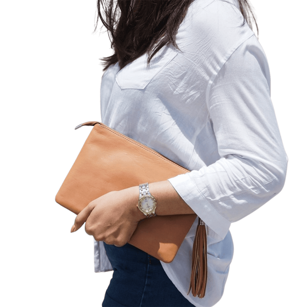 A model hold a 2in1 leather Clutch. It shows how easy to hold the clutch while you go out. It is Cloe 2in1 Leather Clutch from Seminyak Leather Bali in Honey Tan color.