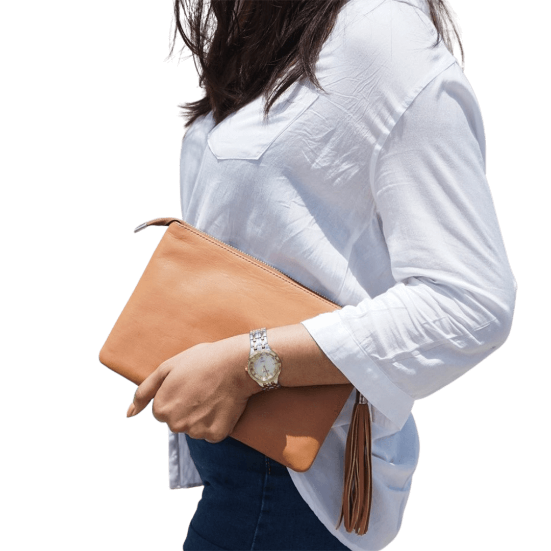 A model hold a 2in1 leather Clutch. It shows how easy to hold the clutch while you go out. It is Cloe 2in1 Leather Clutch from Seminyak Leather Bali in Honey Tan color.