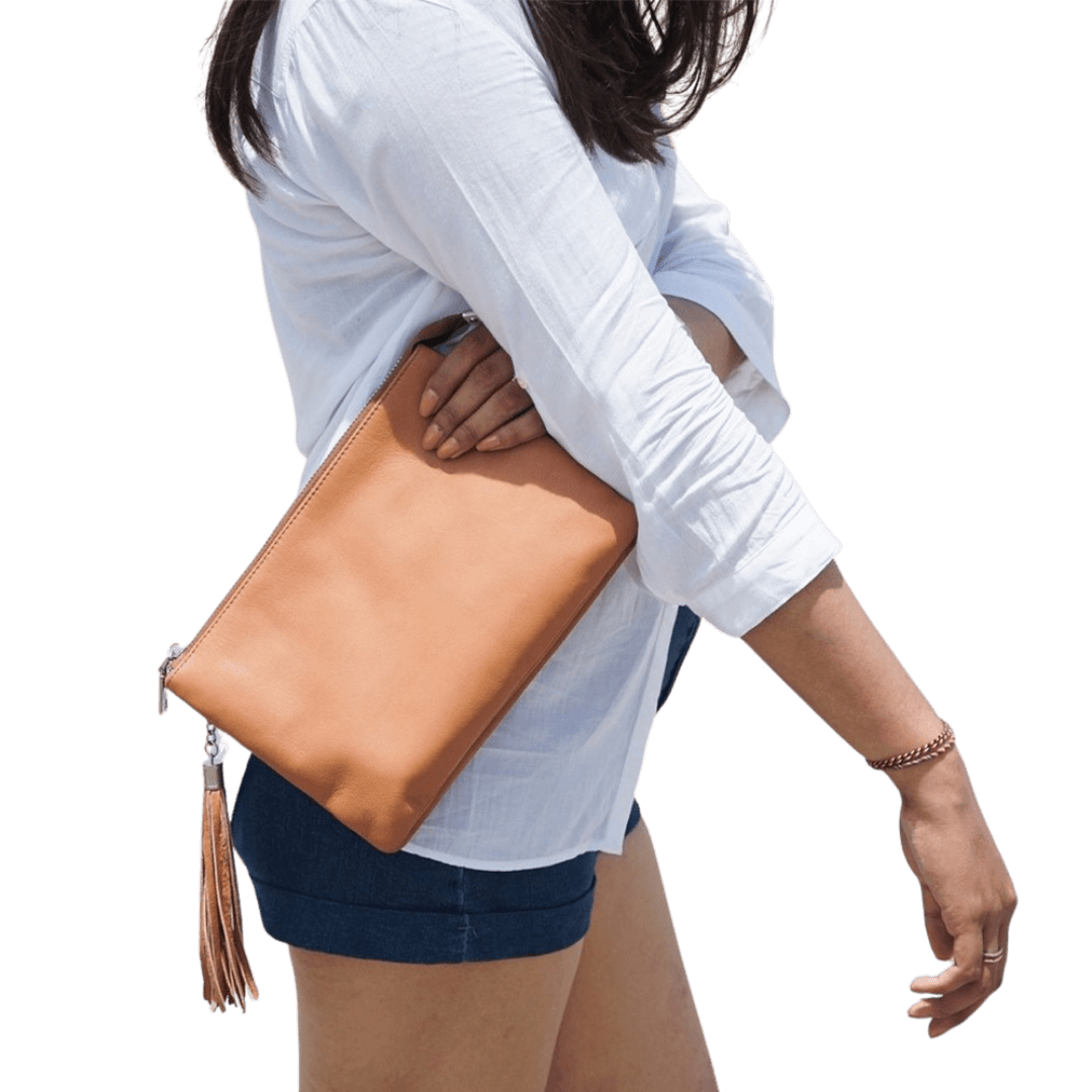 A model hold a 2in1 leather Clutch. It shows the soft texture and the beautiful honey tan color of the goat leather. It is Cloe 2in1 Leather Clutch from Seminyak Leather Bali in Honey Tan color.