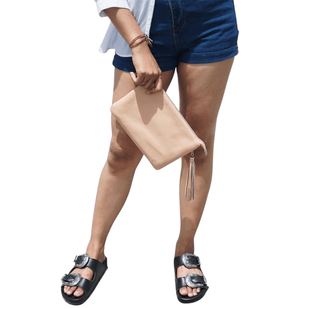 A model hold a 2in1 leather Clutch. It shows how easy to hold the clutch while you go out. It is Cloe 2in1 Leather Clutch from Seminyak Leather Bali in Nude Pink color.