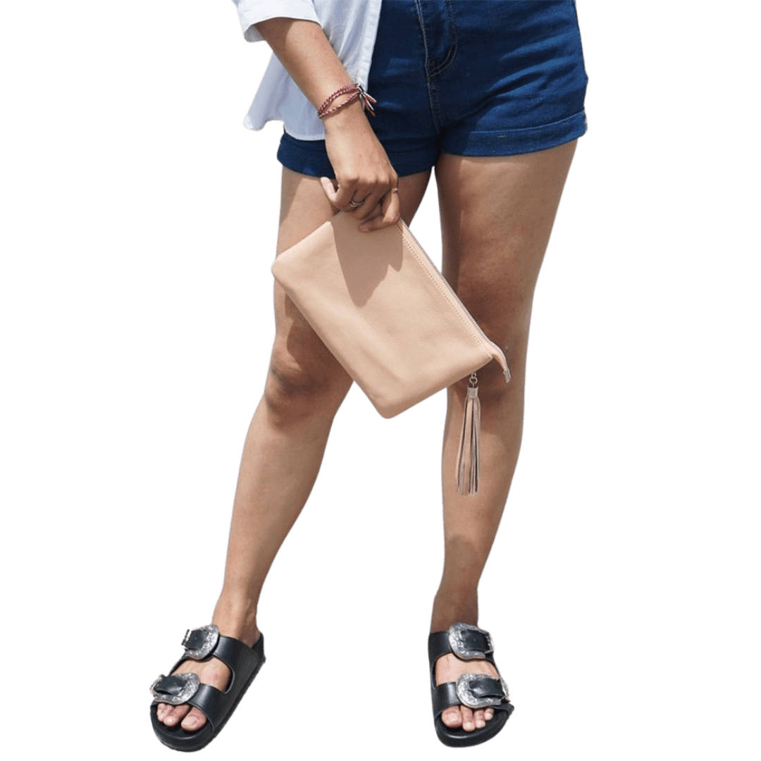 A model hold a 2in1 leather Clutch. It shows how easy to hold the clutch while you go out. It is Cloe 2in1 Leather Clutch from Seminyak Leather Bali in Nude Pink color.