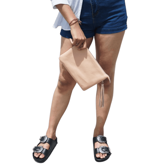 A model hold a 2in1 leather Clutch. It shows how easy to hold the clutch while you go out. It is Cloe 2in1 Leather Clutch from Seminyak Leather Bali in Nude Pink color.