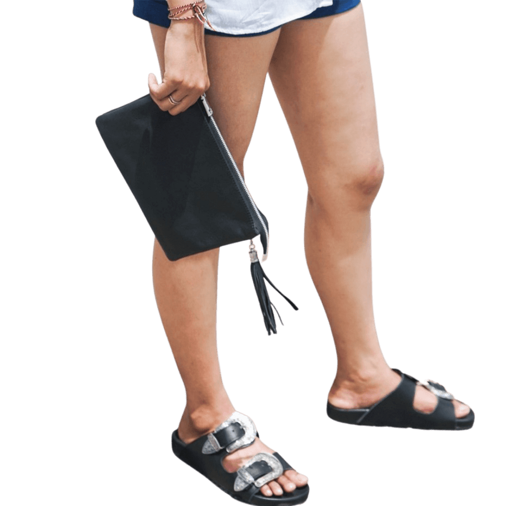 A 2 in 1 leather clutch hold by a model, it shows a texture of the sheep leather which is soft and elastic. You can put your to go things into a beautiful leather clutch. It is Cloe 2in1 Clutch from Seminyak Leather Bali in Black color.