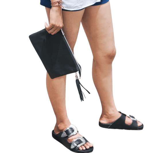 A 2 in 1 leather clutch hold by a model, it shows a texture of the sheep leather which is soft and elastic. You can put your to go things into a beautiful leather clutch. It is Cloe 2in1 Clutch from Seminyak Leather Bali in Black color.