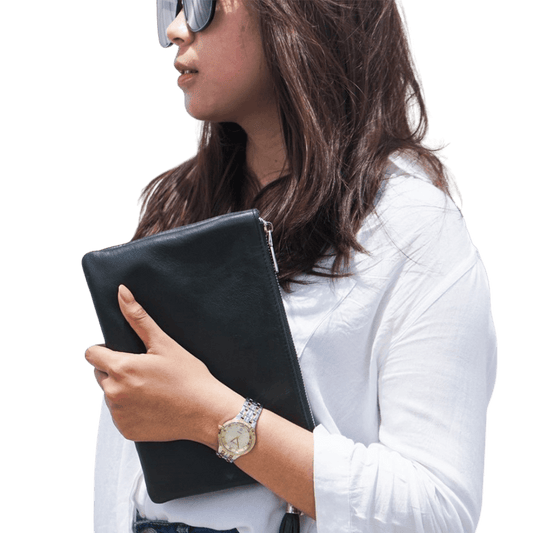 A 2 in 1 leather clutch hold by a model, it shows a texture of the sheep leather which is soft and elastic. You can put your to go thing into a beautiful leather clutch. It is Cloe 2in1 leather clutch from Seminyak Leather Bali, you can use it as a formal or informal style.