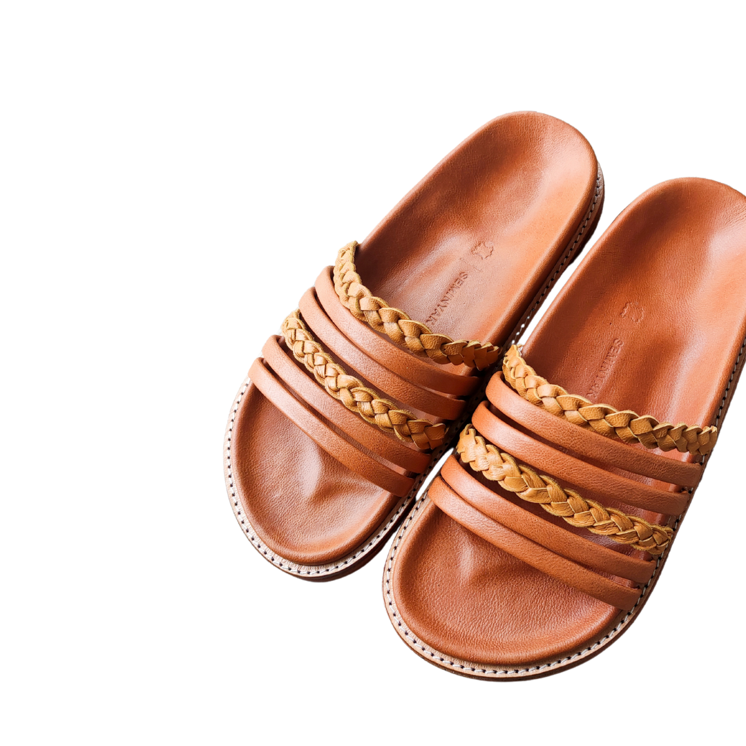 A slide with a color combination of summer tan and honey tan. The braid detail on the strap doesn't make the sandals look boring. These are Dayana Slides from Seminyak Leather Bali.