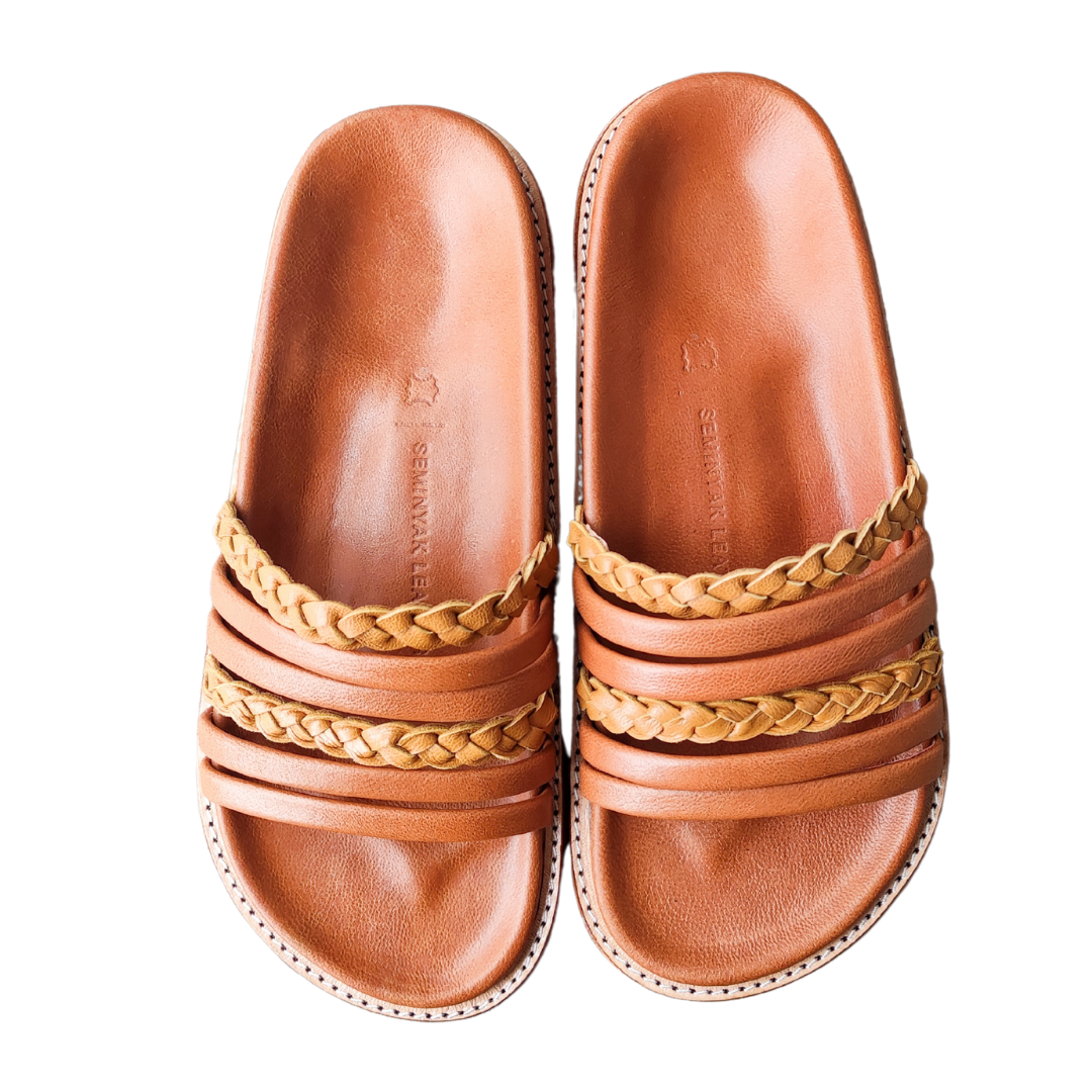 A slide with a color combination of summer tan and honey tan. The braid detail on the strap doesn't make the sandals look boring. These are Dayana Slides from Seminyak Leather Bali.