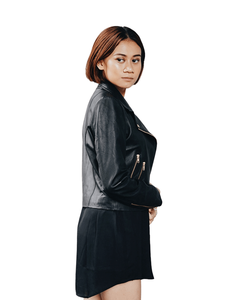 A model with a short hair stands aside wearing a leather Jacket from Seminyak Leather Bali. A black leather jacket with a gold accessories and two zip pocket in each side with a detail biker on the neck. We proudly present Eliz biker leather jacket for you.