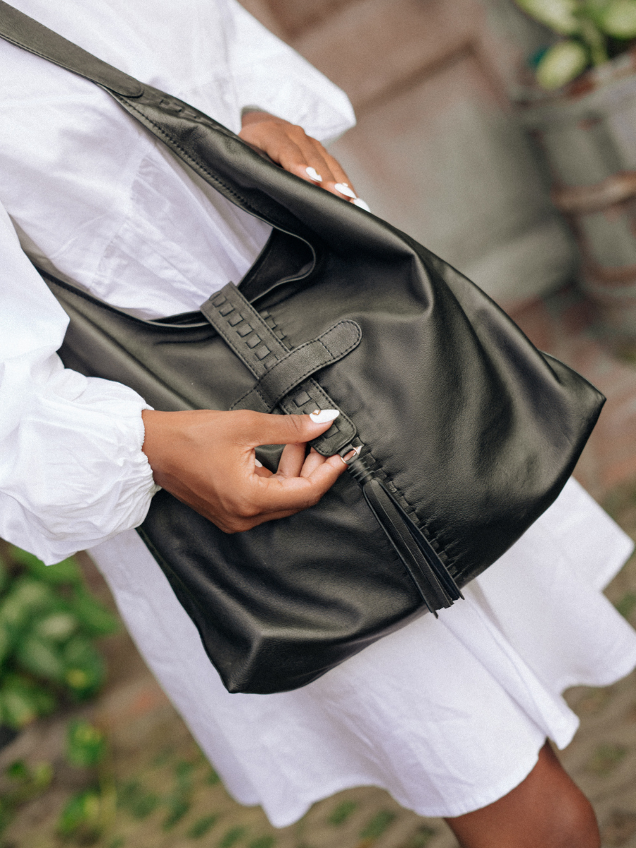A picture shows the detail of the bag, the tassel detail on the magnet closure and a woven in each side of the bag. It is Ella Hobo Bag in Black from Seminyak Leather Bali
