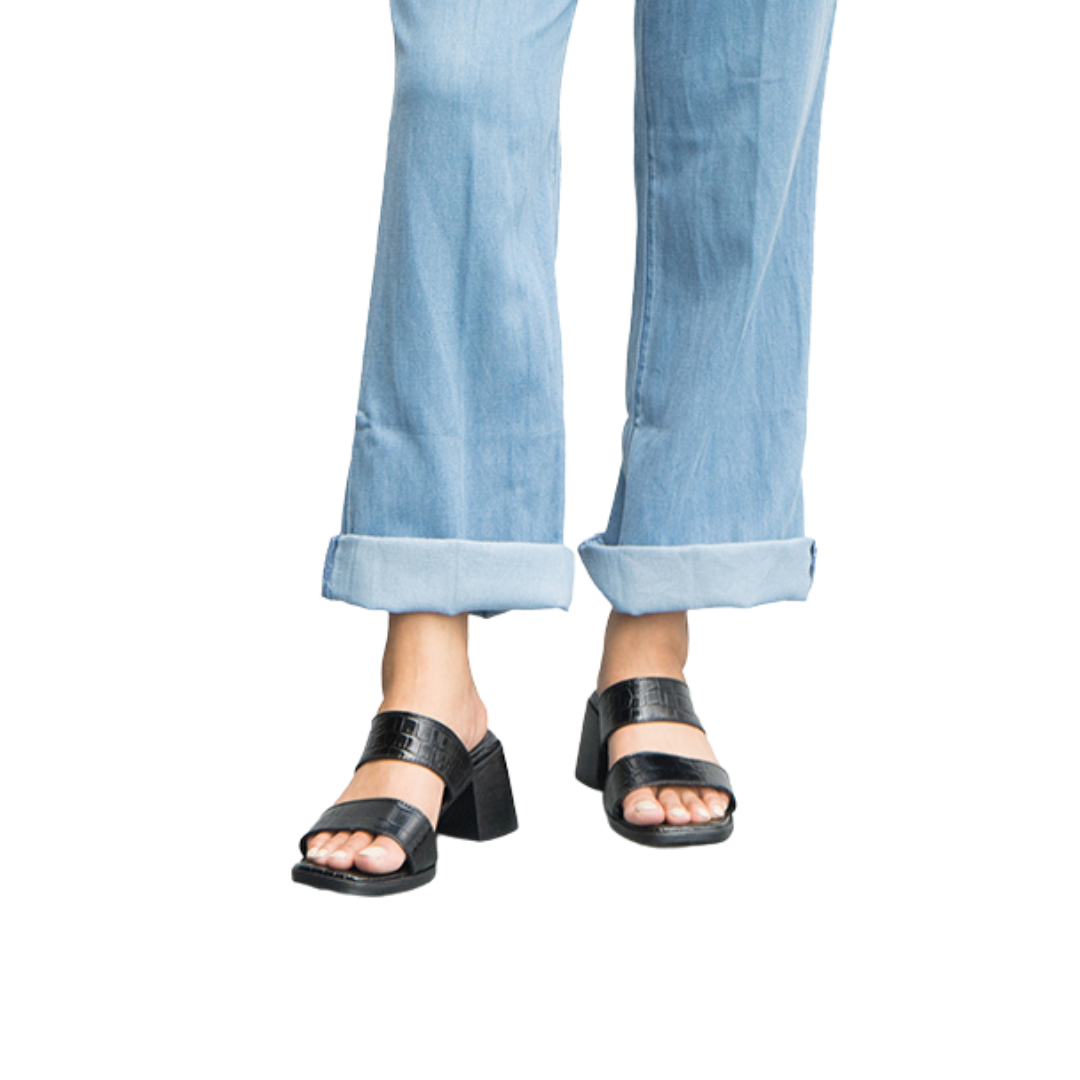 A pair of black FIONA heels with double straps and 7 cm block heels, worn by a person with blue jeans designs by Seminyak Leather Bali.