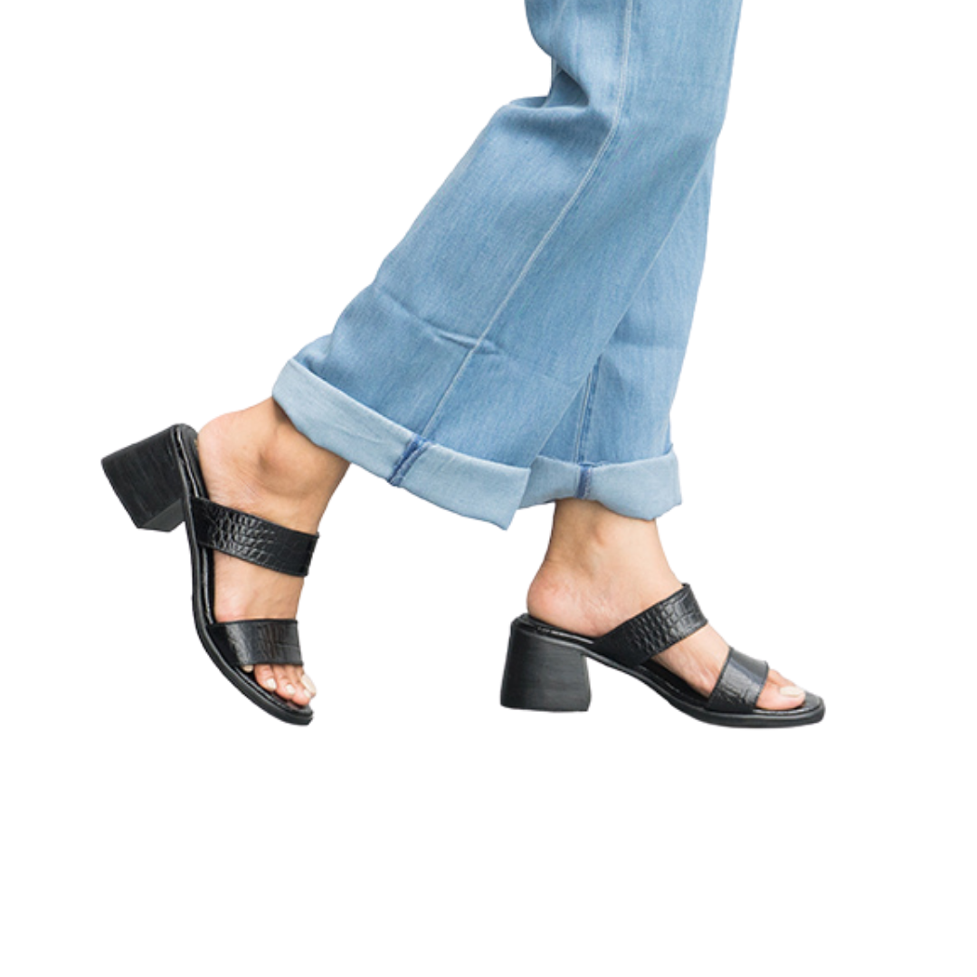 A pair of black FIONA heels with double straps and 7 cm block heels, worn by a person with blue jeans designs by Seminyak Leather Bali.