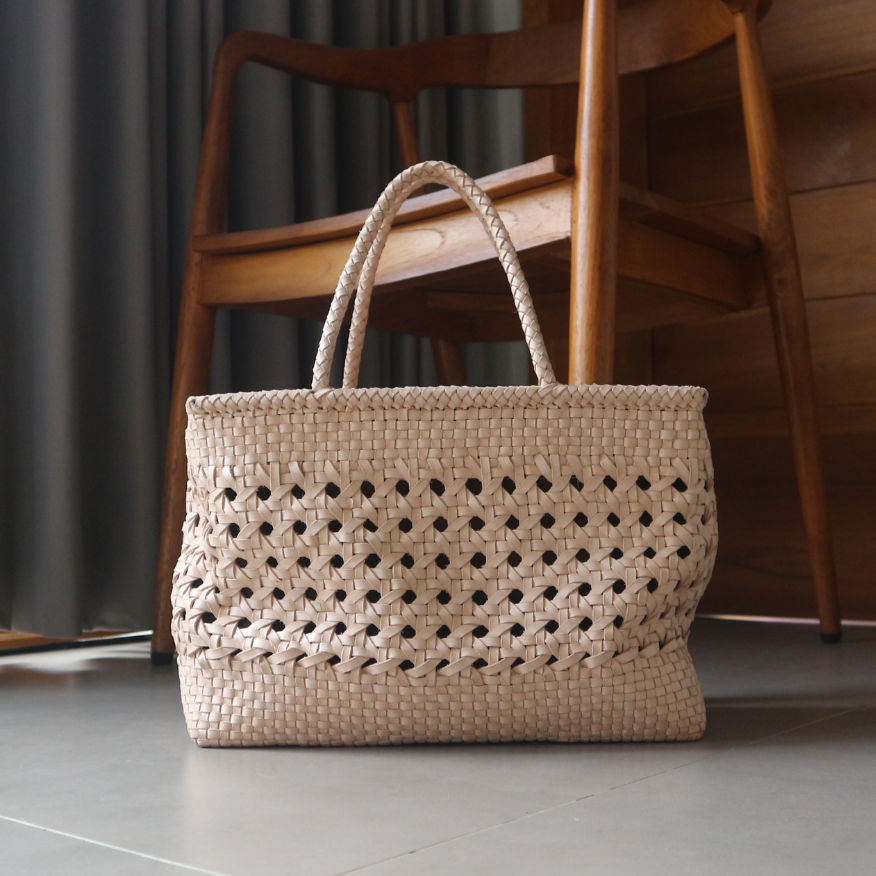A blush medium-sized rectangle handbag made of hand-weaved leather with braided handle and chick-eye weave on the body by Seminyak Leather Bali. A blend of modern elegance and artisanal charm, crafted with meticulous attention to detail.