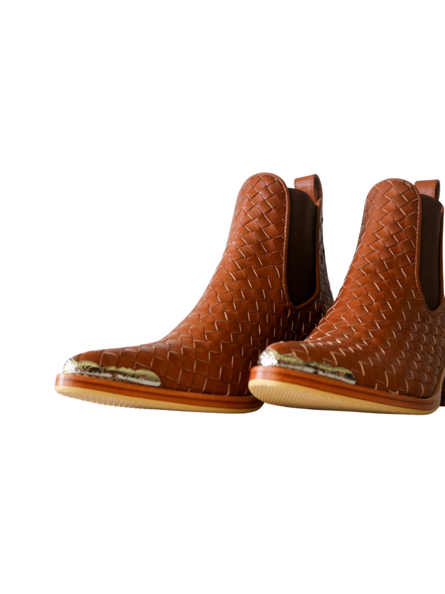 Ankle boots with leather woven detailing in a slim fit cut by Semminyak Leather Bali. Elastic closure with carved metal accents on toe cap and heel. 5 cm wooden heel with a pointy toe design. Stylish and sophisticated footwear with a natural finish, perfect for making a fashion statement.