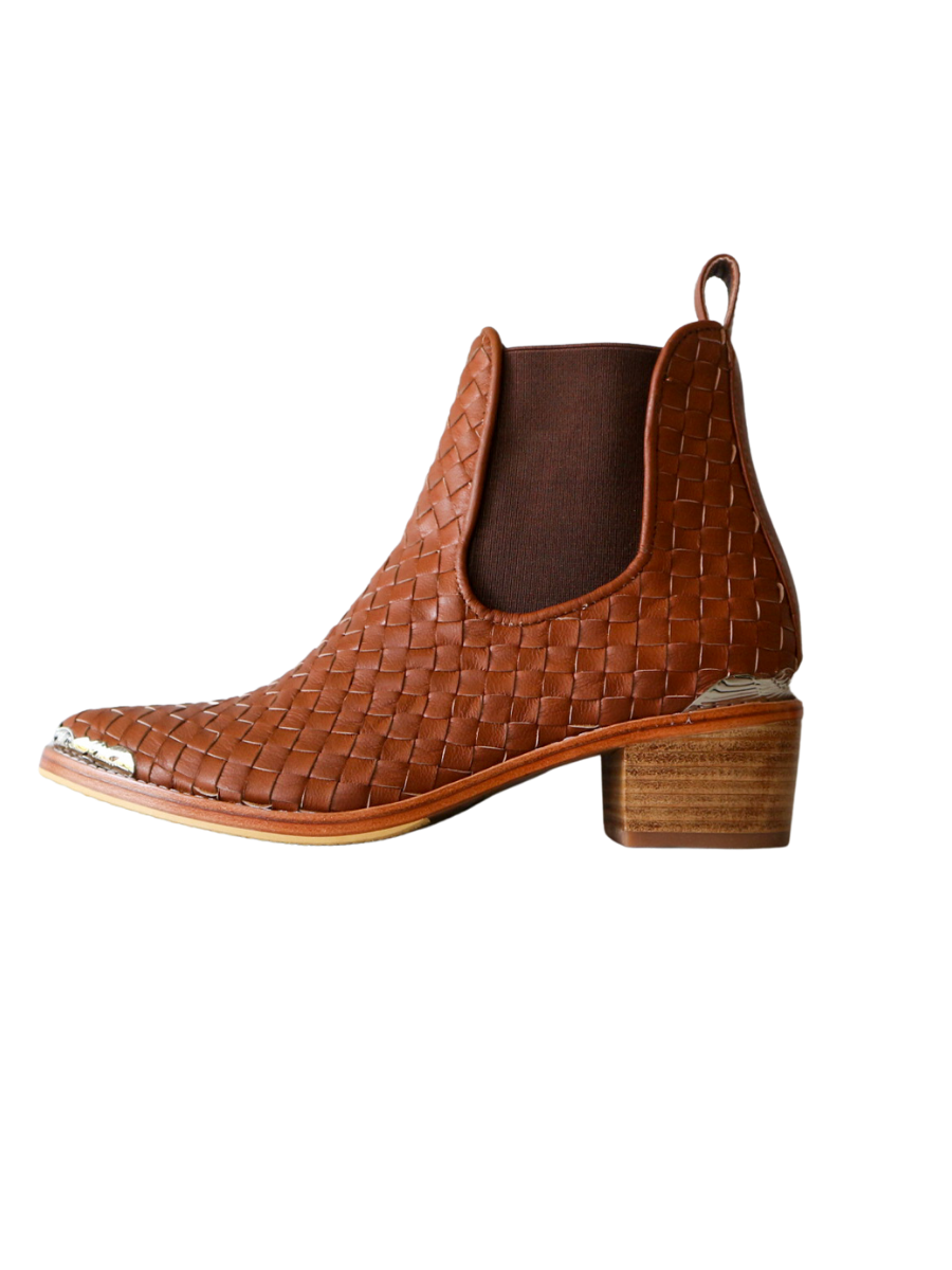 Ankle boots with leather woven detailing in a slim fit cut by Semminyak Leather Bali. Elastic closure with carved metal accents on toe cap and heel. 5 cm wooden heel with a pointy toe design. Stylish and sophisticated footwear with a natural finish, perfect for making a fashion statement.