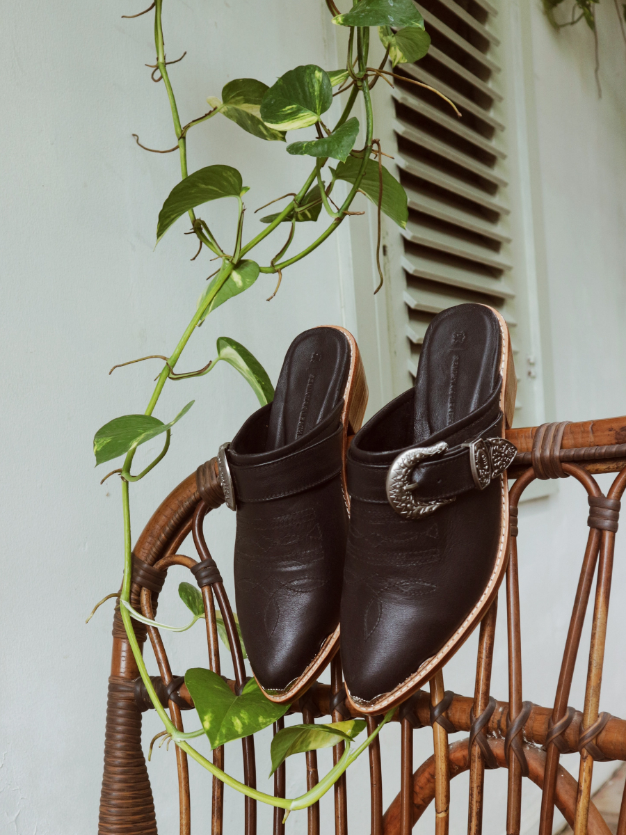 Black pointy toe mules by Seminyak Leather Bali with western-style stitching on vamp and carved metal toe cap. 5 cm wooden Cuban heel in a natural finish. A blend of Western charm and contemporary elegance, all made of leather.