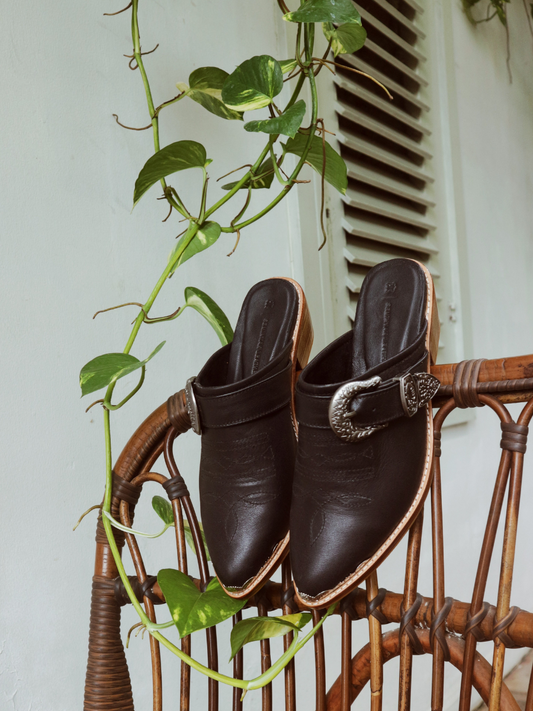 Black pointy toe mules by Seminyak Leather Bali with western-style stitching on vamp and carved metal toe cap. 5 cm wooden Cuban heel in a natural finish. A blend of Western charm and contemporary elegance, all made of leather.
