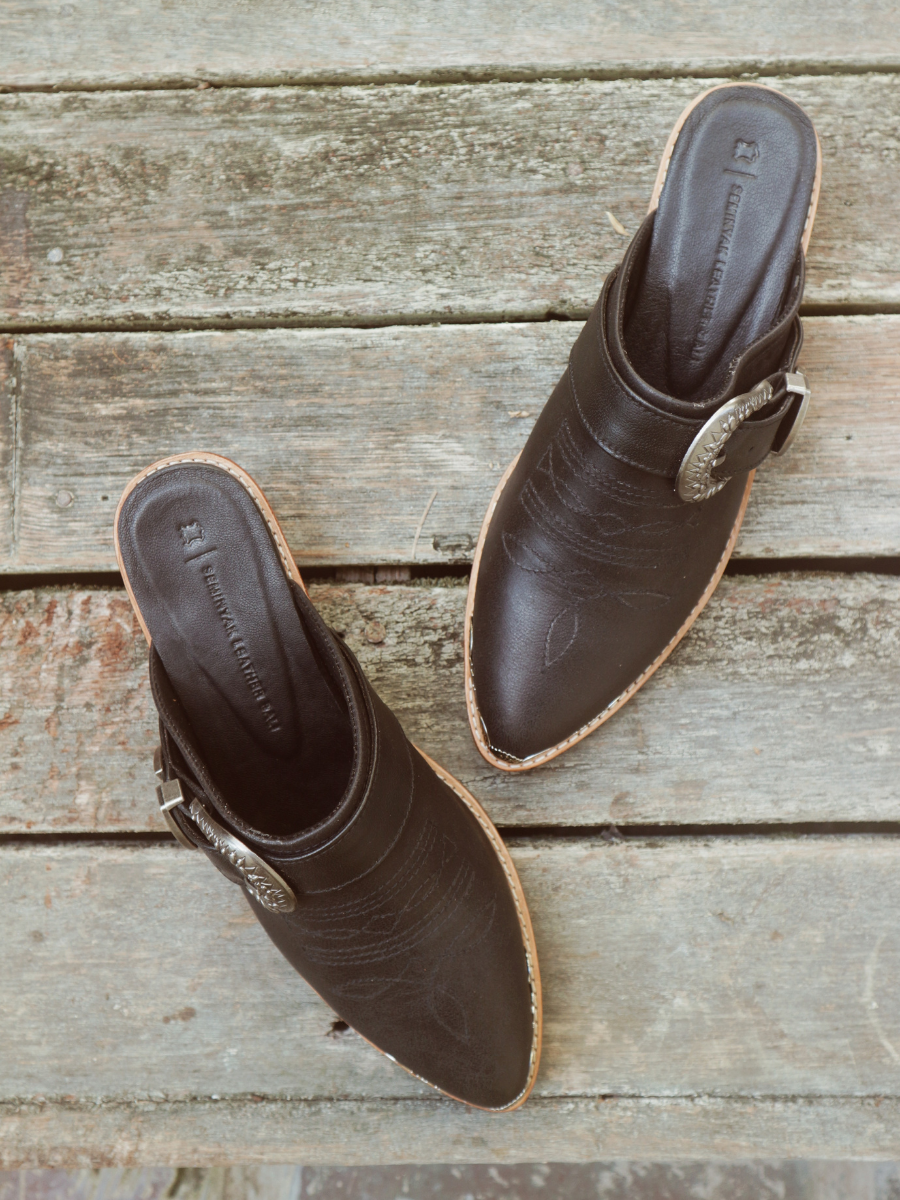 Black pointy toe mules by Seminyak Leather Bali with western-style stitching on vamp and carved metal toe cap. 5 cm wooden Cuban heel in a natural finish. A blend of Western charm and contemporary elegance, all made of leather.