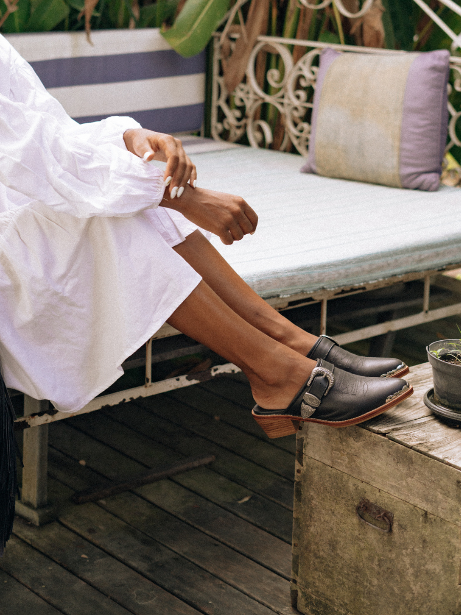 Black pointy toe mules by Seminyak Leather Bali with western-style stitching on vamp and carved metal toe cap. 5 cm wooden Cuban heel in a natural finish. A blend of Western charm and contemporary elegance, all made of leather.