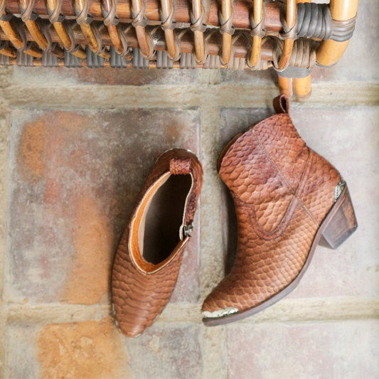 Ankle boots by Seminyak Leather Bali made of snakeskin leather in antique brown color. Loose fit cut with carved metal detailing on the toe cap and heel. 5 cm wooden Cuban-style heel. Zipper closure. Edgy and chic footwear for bold fashion statements.