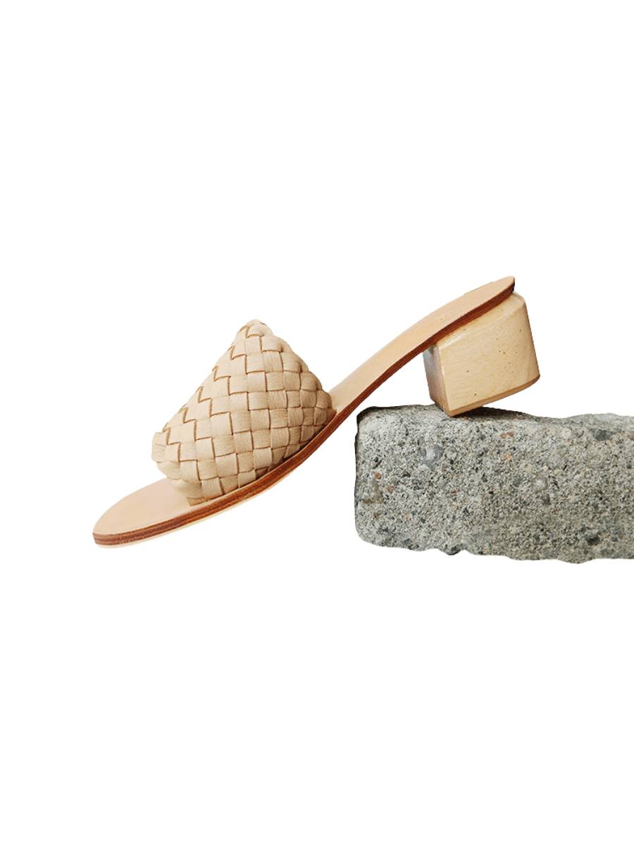 A pair of beige woven heels with wooden block heels designs by Seminyak Leather Bali.