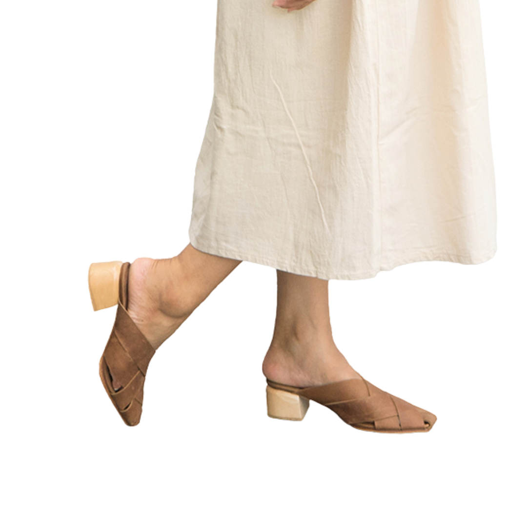 Heeled mules with wide woven leather upper by Seminyak Leather Bali, providing a custom fit. 5 cm wooden block heel in a natural finish. Crazyhorse cow leather sole with nonslip rubber for confident steps. A blend of style and comfort for elevated fashion.